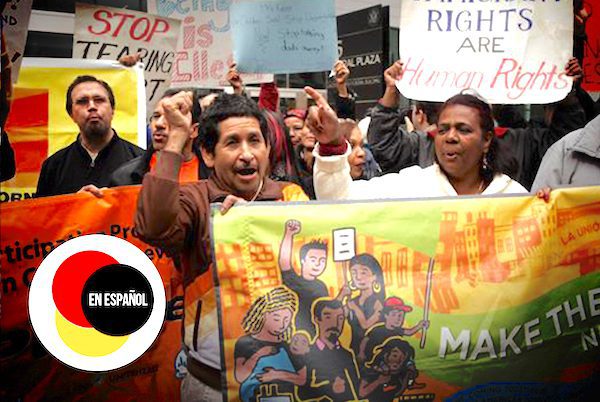 Advocates holding signs in support of immigrant rights. A logo reads, “En Español.”