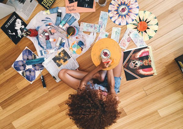 A young artist photographed from above while painting vinyl records.