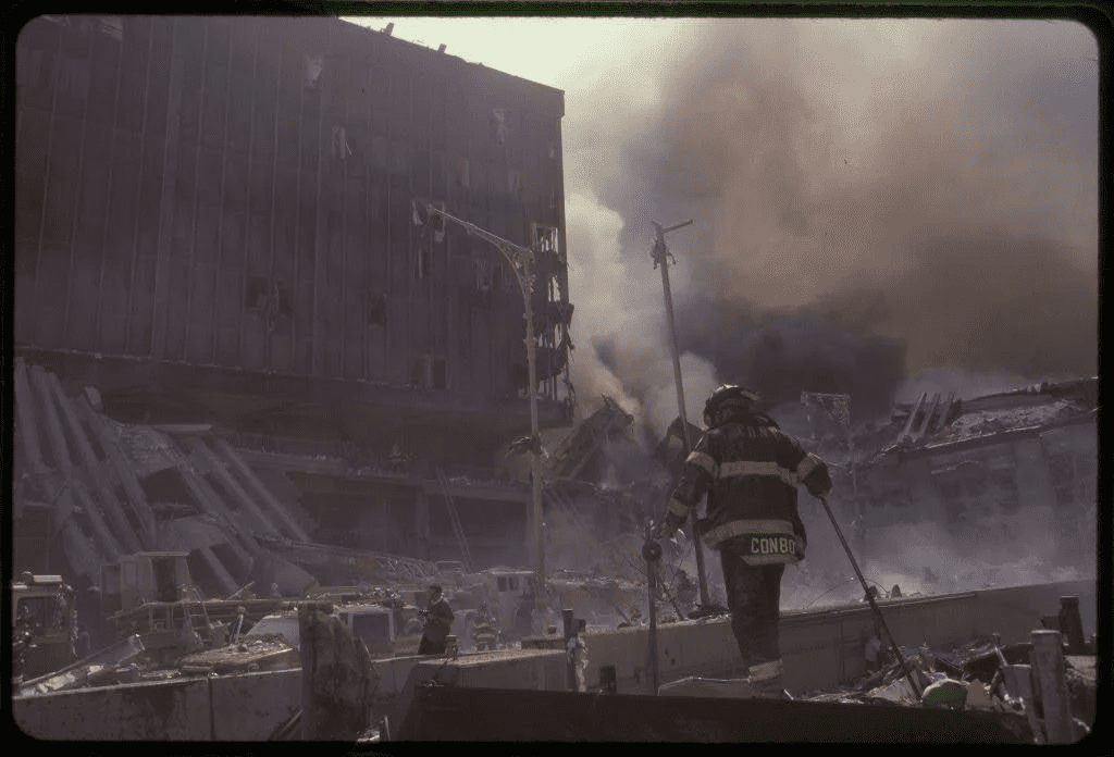 Firefighter running towards a burning building.