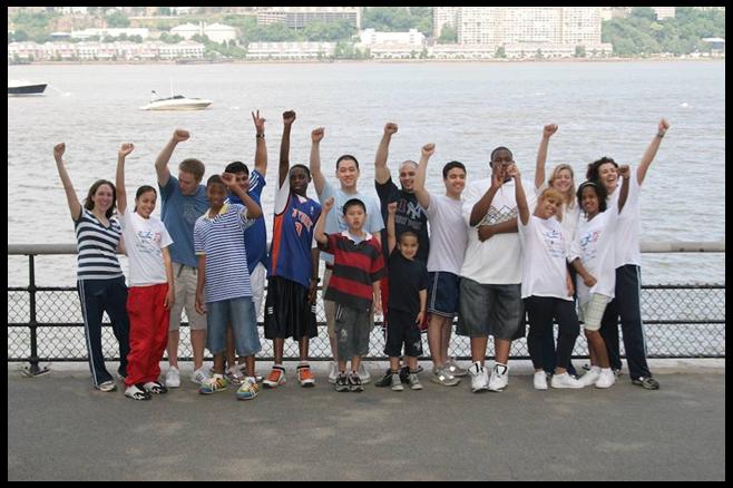 Adults and children raising their arms.