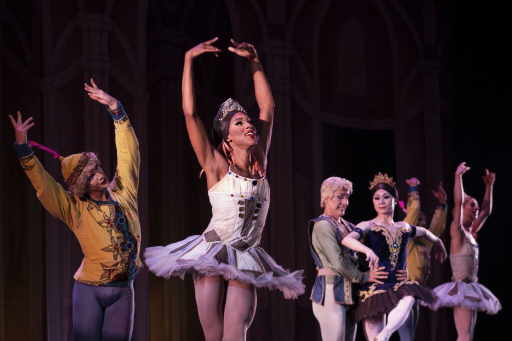 Ballet dancers performing in drag on stage in costume.