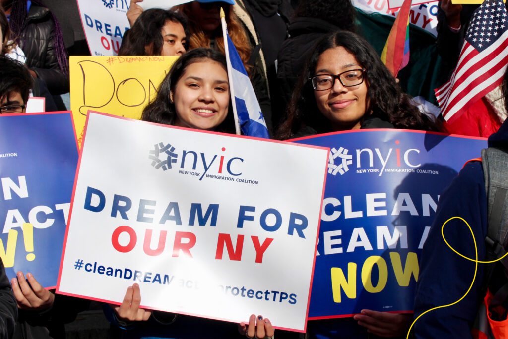 Two women holding signs at a rally.