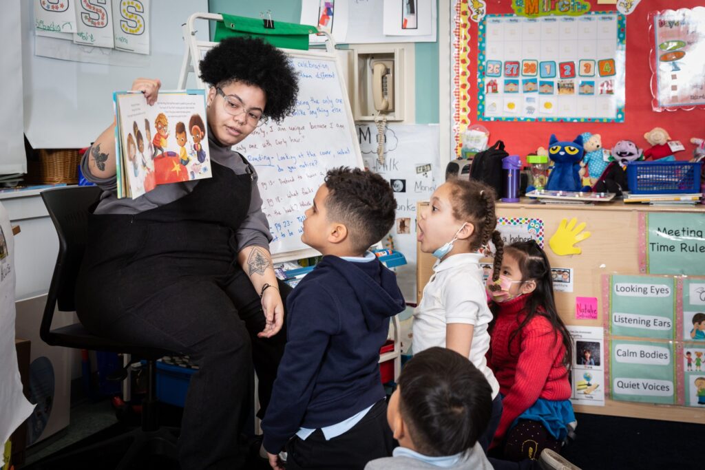 An adult group leader reads to the Ready Readers kindergarten group.